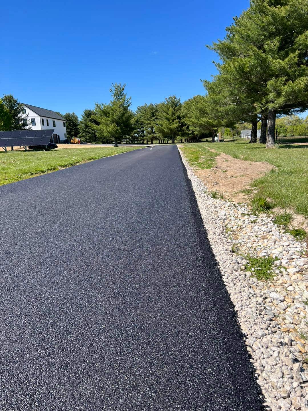Freshly paved driveway with clean stone borders by Original Asphalt